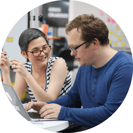 Two members of a Scrum team work together to put their Agile project management skills into action.