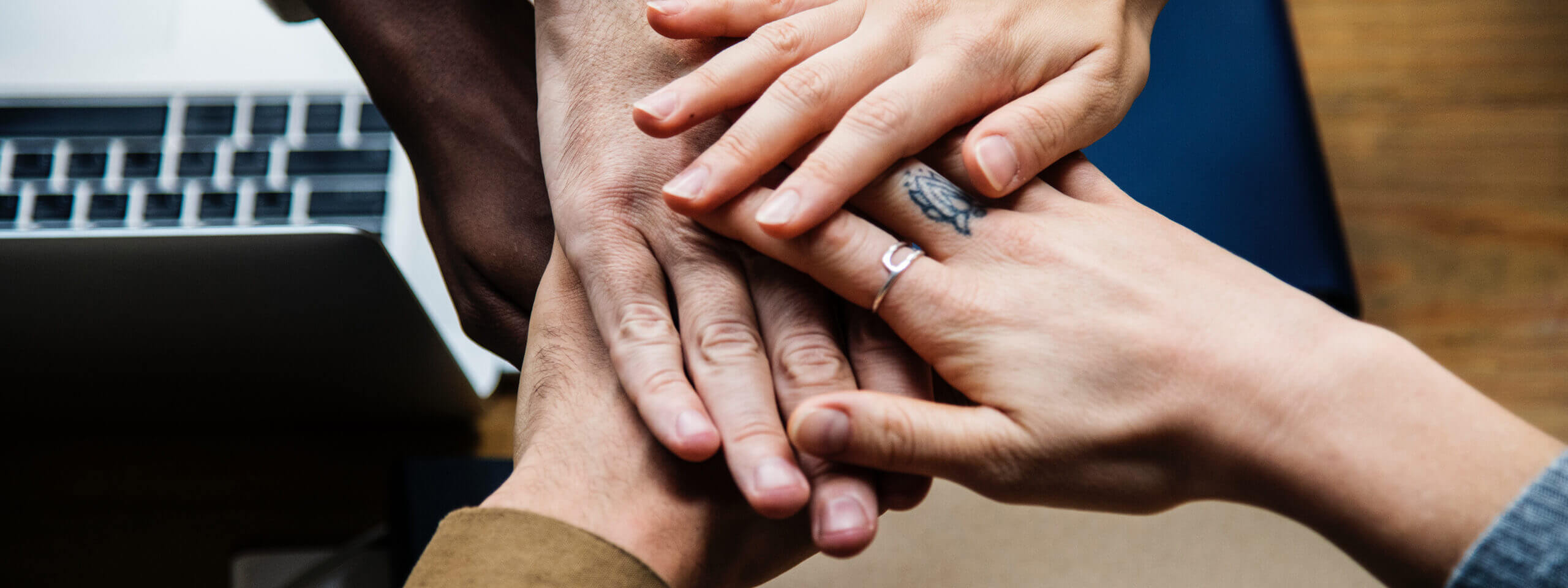 A team join hands at a discovery workshop. The Team Charter bonds the team.