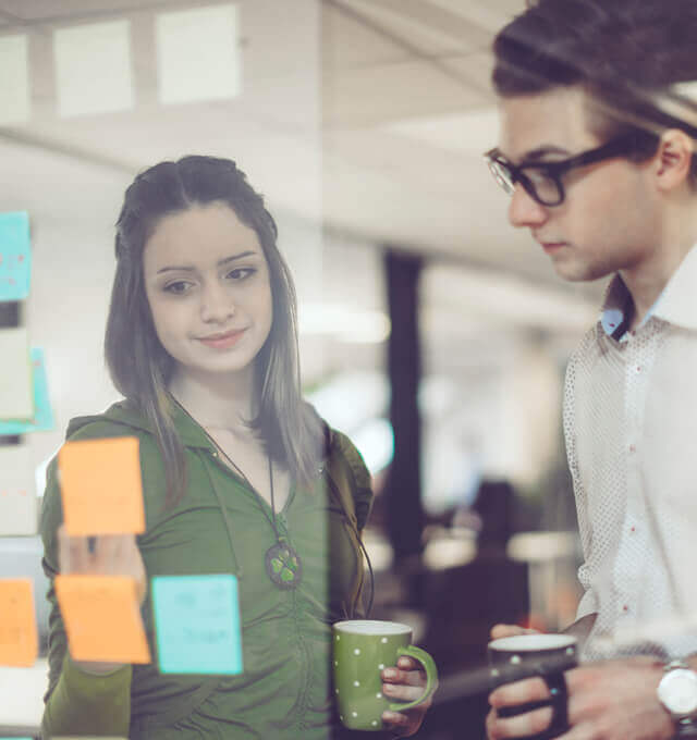 Two members of a project team discuss success criteria for their Success Sliders exercise.