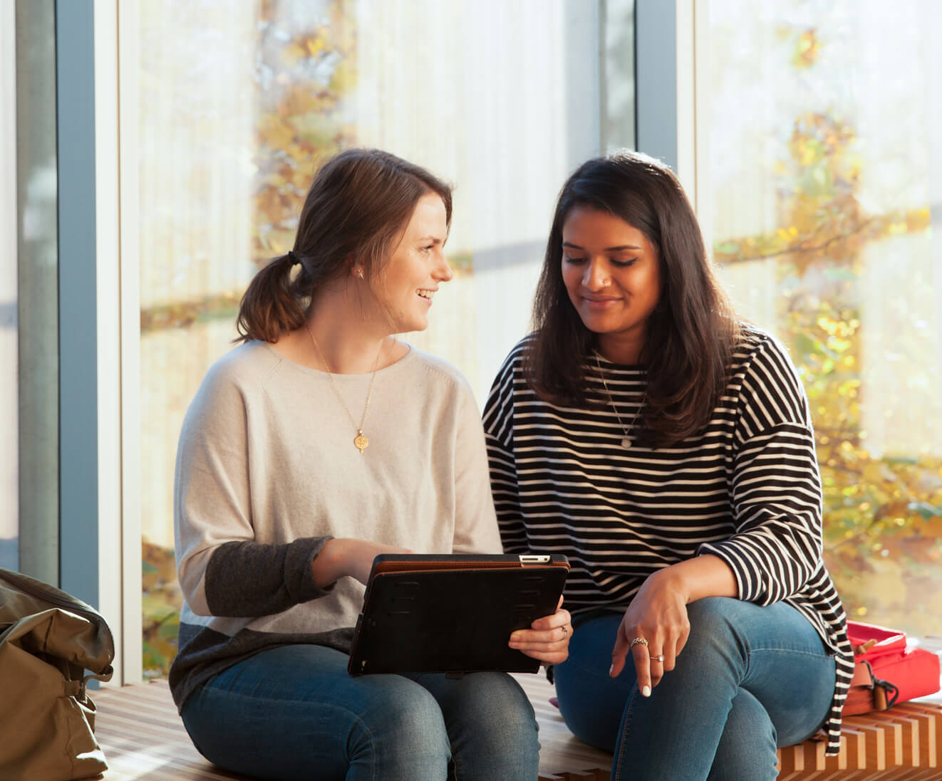 Two women exploring the new Archives site on a tablet.